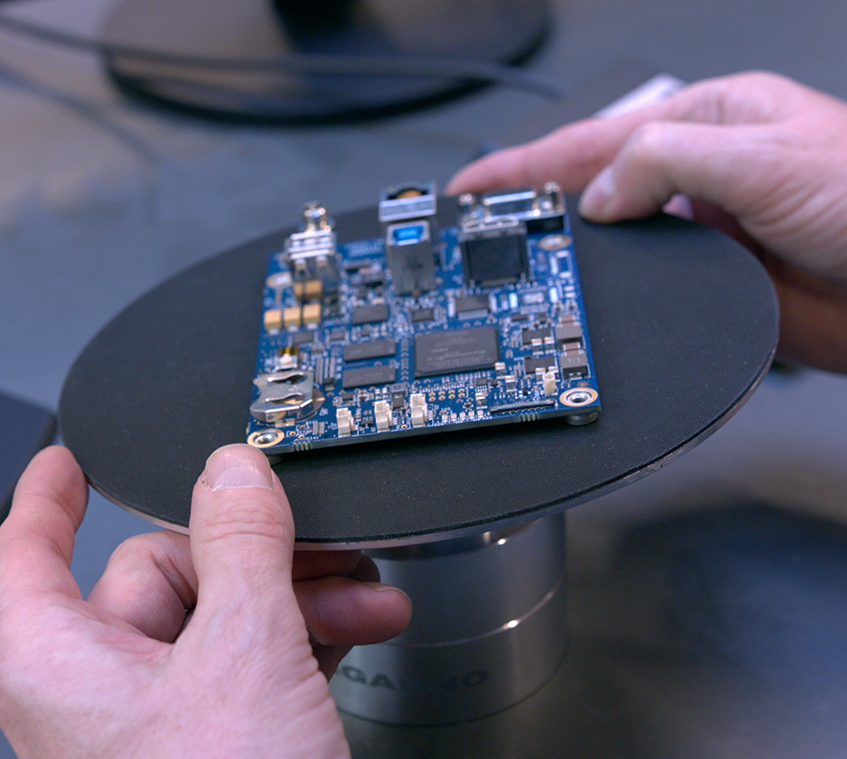 Operator using tilting table and digital microscope to inspect printed circuit board