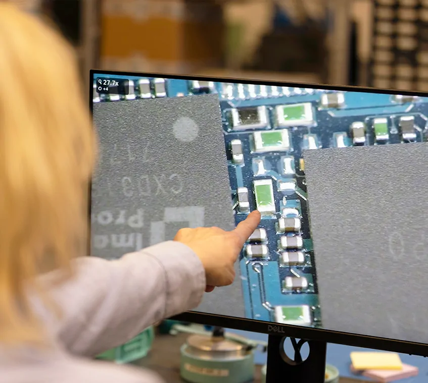 Woman using a solder microscope to inspect PCB