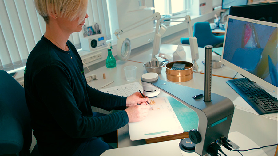 Woman using a digital microscope to inspect seed