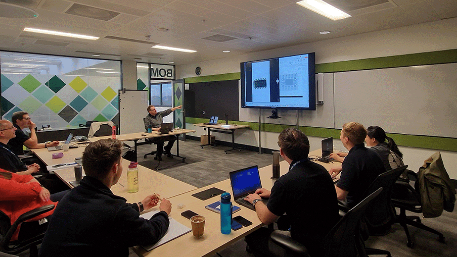 Class room location with electronic failure analysis professionals looking at a projector with live image from TAGARNO ZIP digital microscope